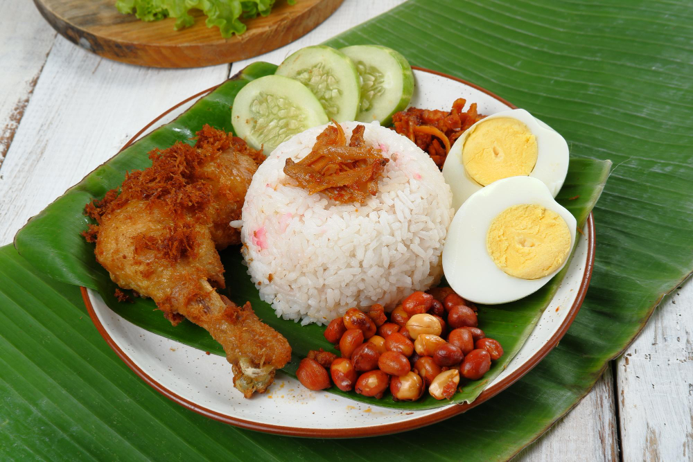 Nasi Uduk is a traditional Indonesian dish consisting of steamed rice cooked with coconut milk and served with a variety of side dishes. Nasi Uduk is a traditional Indonesian dish consisting of steamed rice cooked with coconut milk and served with a variety of side dishes.
